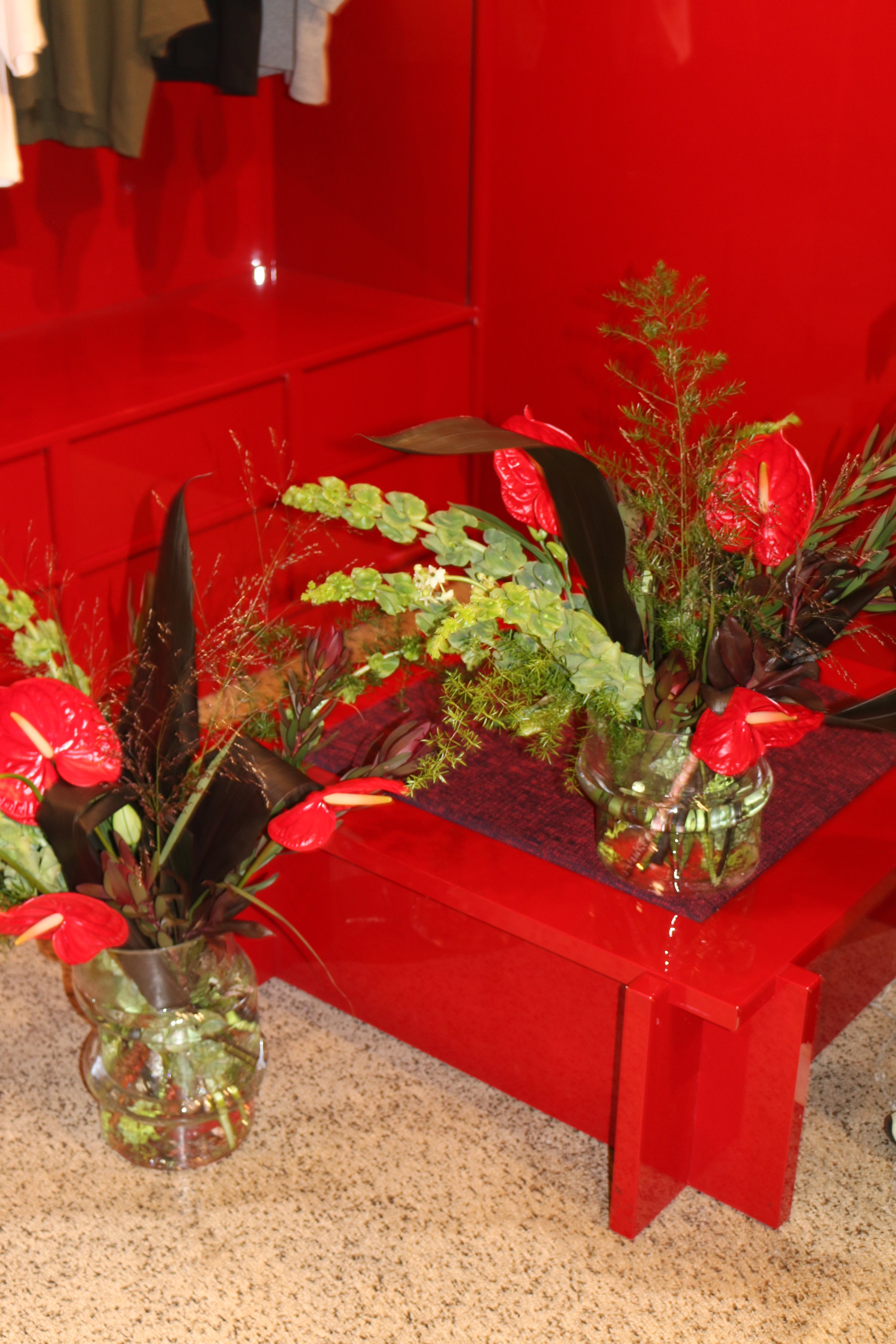 December floral arrangement for Baum und Pferdgarten in rich red tones, styled with seasonal winter flowers.
